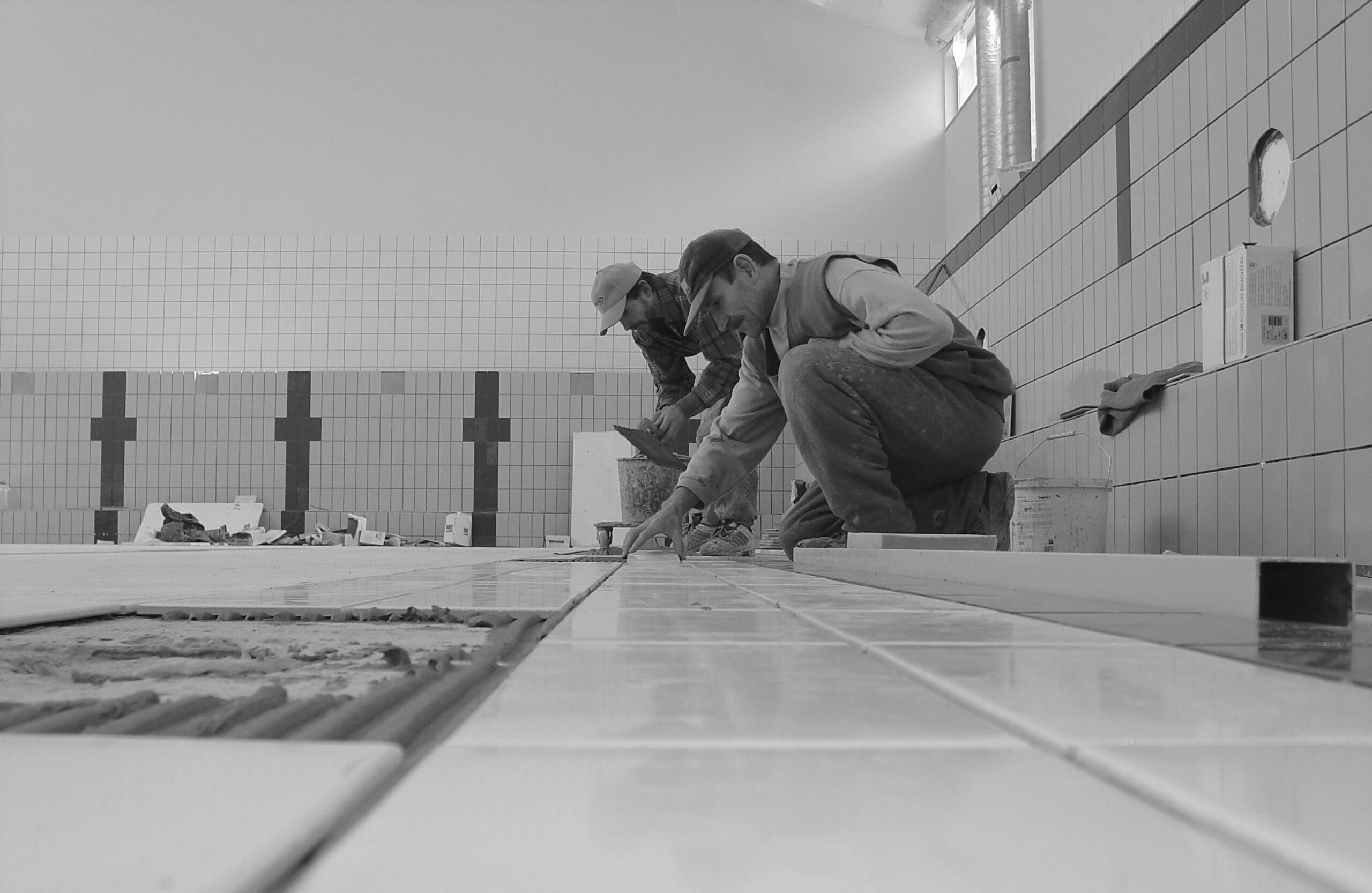 Trabajadores profesionales colocando azulejos en el interior de un baño, demostrando experiencia en construcción