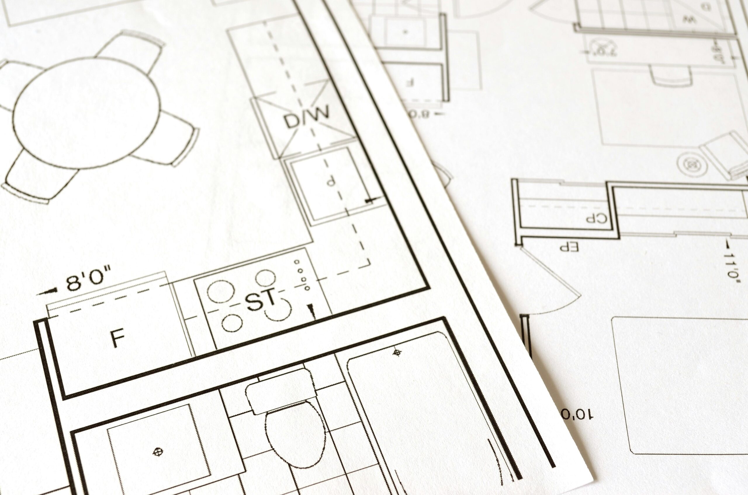 Close-up view of an architectural floor plan on paper showcasing detailed room layouts and measurements